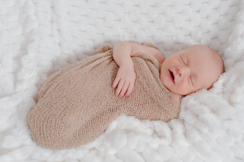 Nouveau-né endormi en cocon beige au studio Pierre Lepoutre