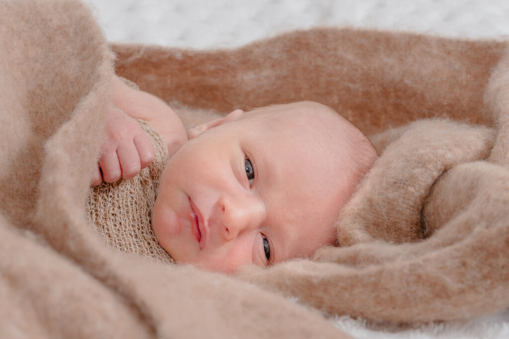Bébé dans un plaid blanc, lumière douce et naturelle