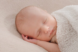 Portrait de nouveau-né endormi en position fœtale